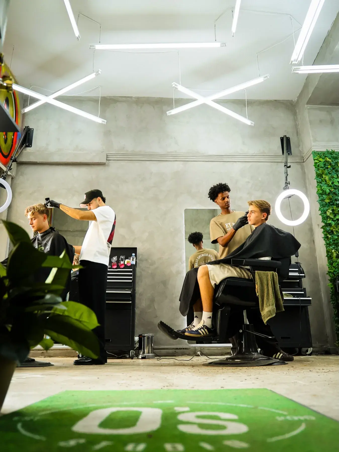 Salonen hos O's Studio med barbers i gang og det grønne O's-gulvtæppe