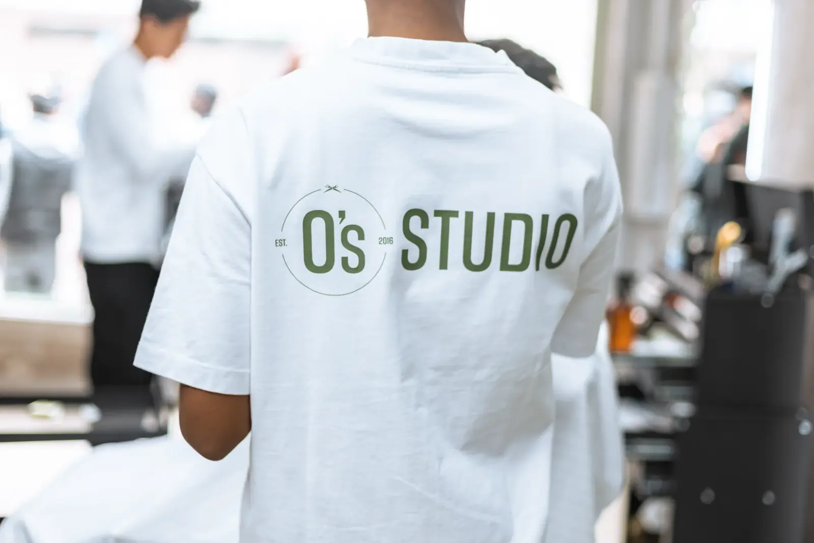 Barber i hvid O's Studio t-shirt i salonen