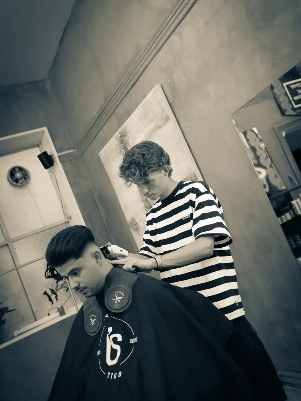 Barber klipper en kunde i stolen hos O's Studio